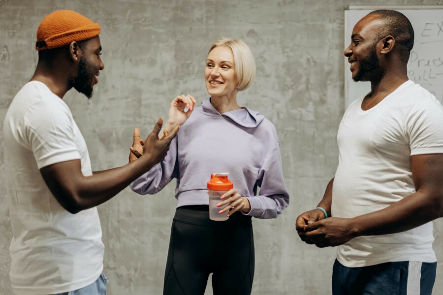 Three people standing discussing their course